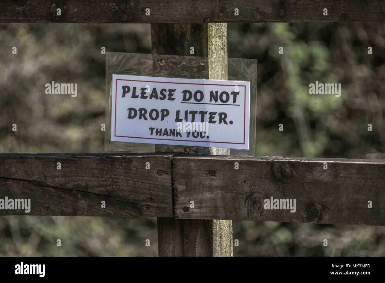 Do not drop litter sign on a wooden fence Stock Photo