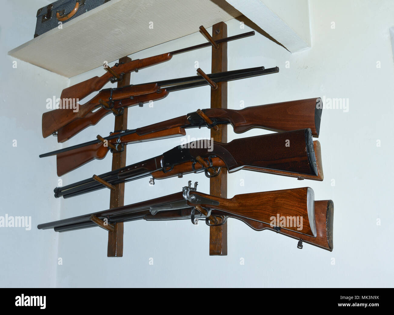 Old French hunting guns hang on the wall Stock Photo - Alamy