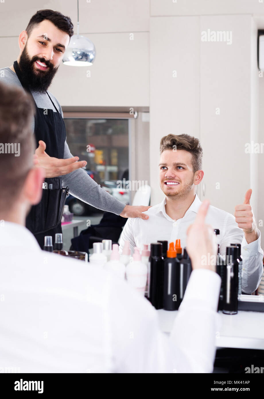 Adult American Male Hairdresser Showing Resulting Haircut To Client At Hair Salon Stock Photo Alamy