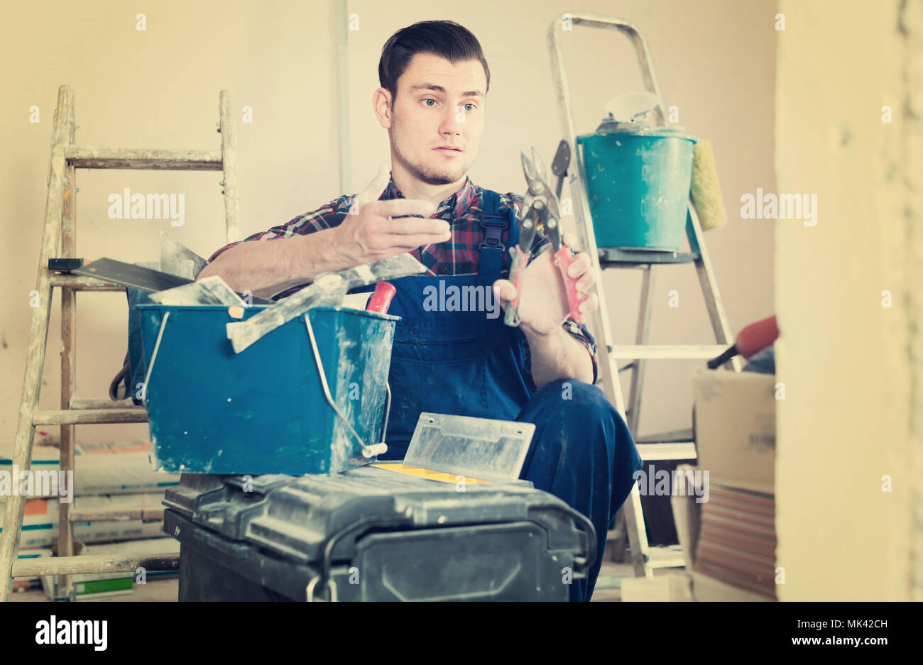 Young professional builder handyman choosing necessary tool in toolbox Stock Photo