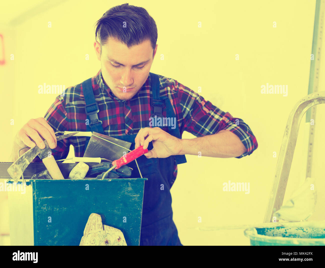 Handyman searching in his toolbox for necessary tools Stock Photo