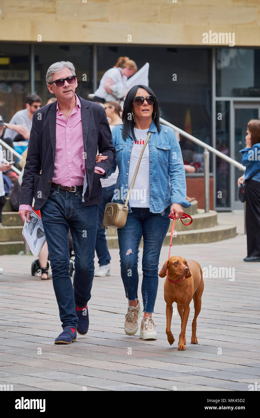 Couple walking a dog in city Glasgow Scotland Stock Photo