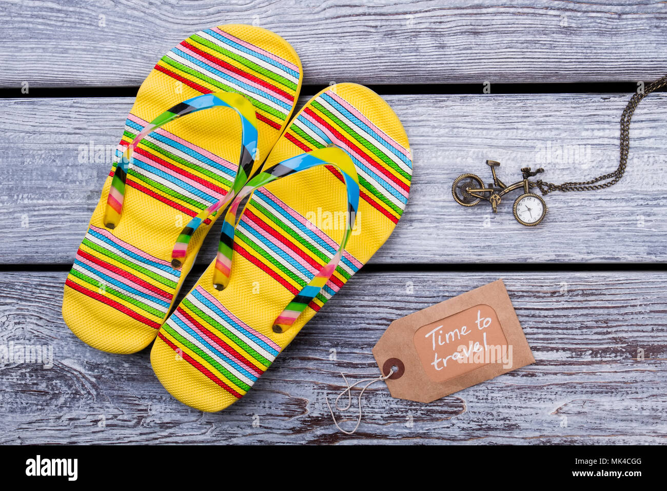 Time To Travel Concept Sandals Flip Flops And Clock On Wooden