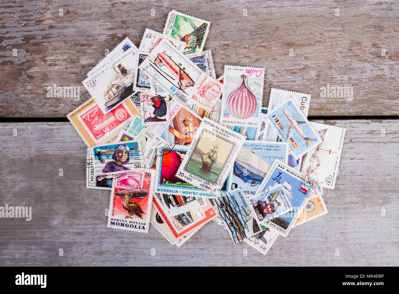 05.01.2017 - Kyiv, Ukraine. Pile of different post stamps. Top view, flat lay. Wooden desk surface background. Stock Photo