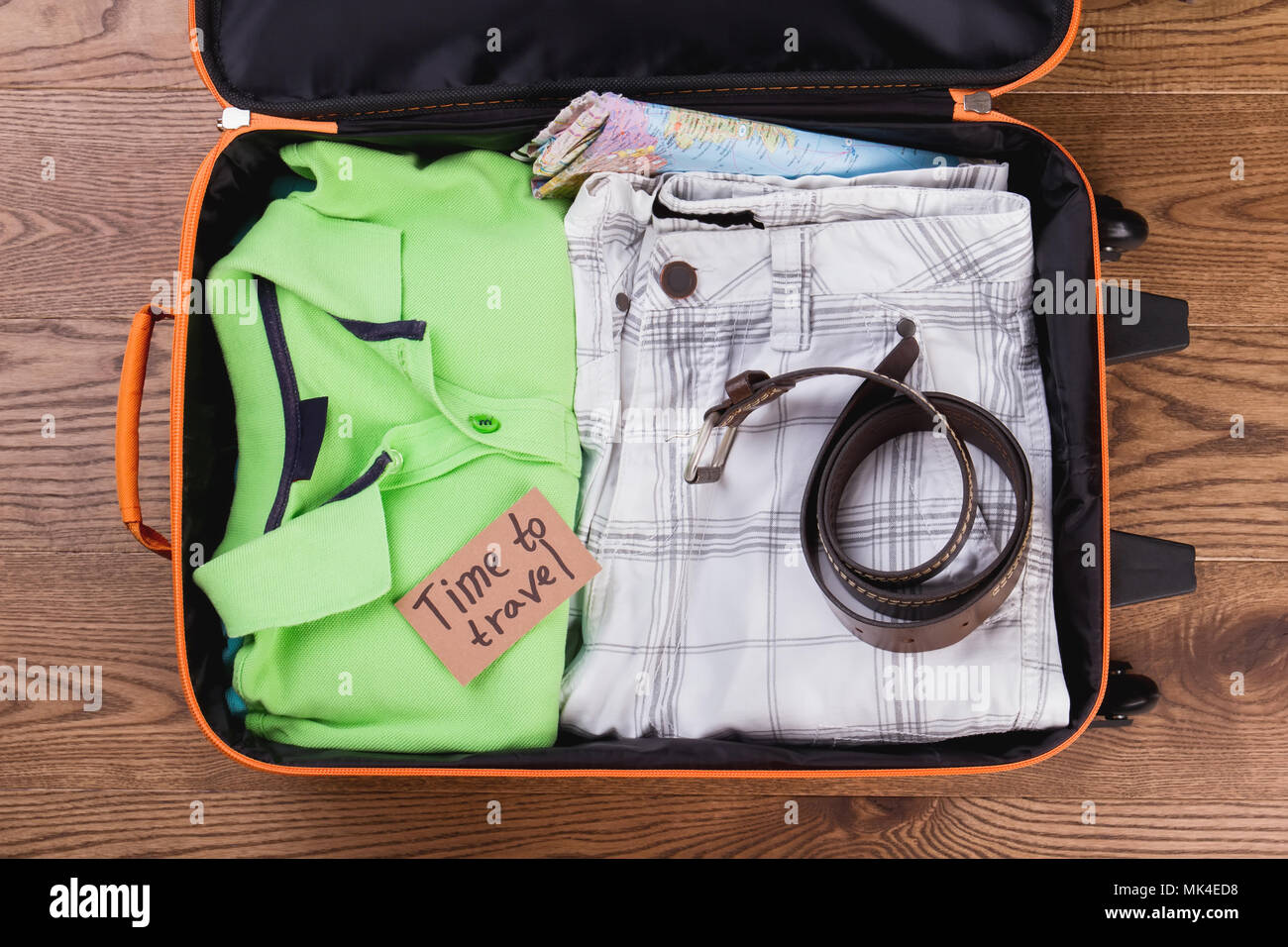 Summer vacation clothes and accessories for traveling. Folded male apparel in suitcase. Stock Photo