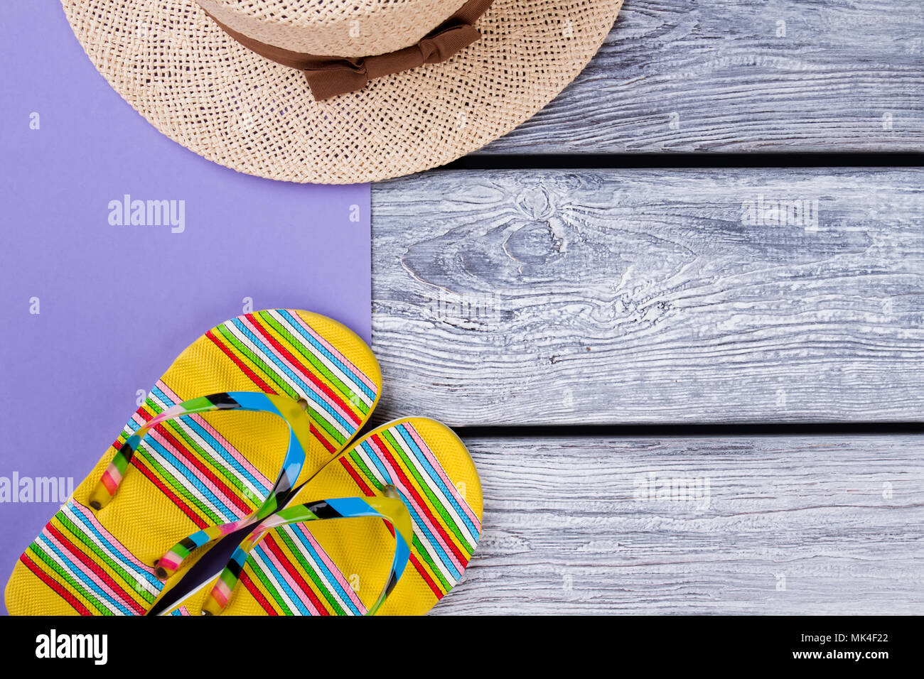 flip-flops-and-straw-hat-flat-lay-top-view-wooden-desk-surface
