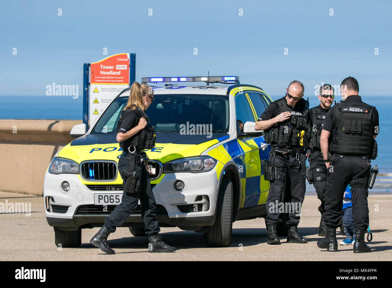 Armed police men & women with vehicle interacting with the general