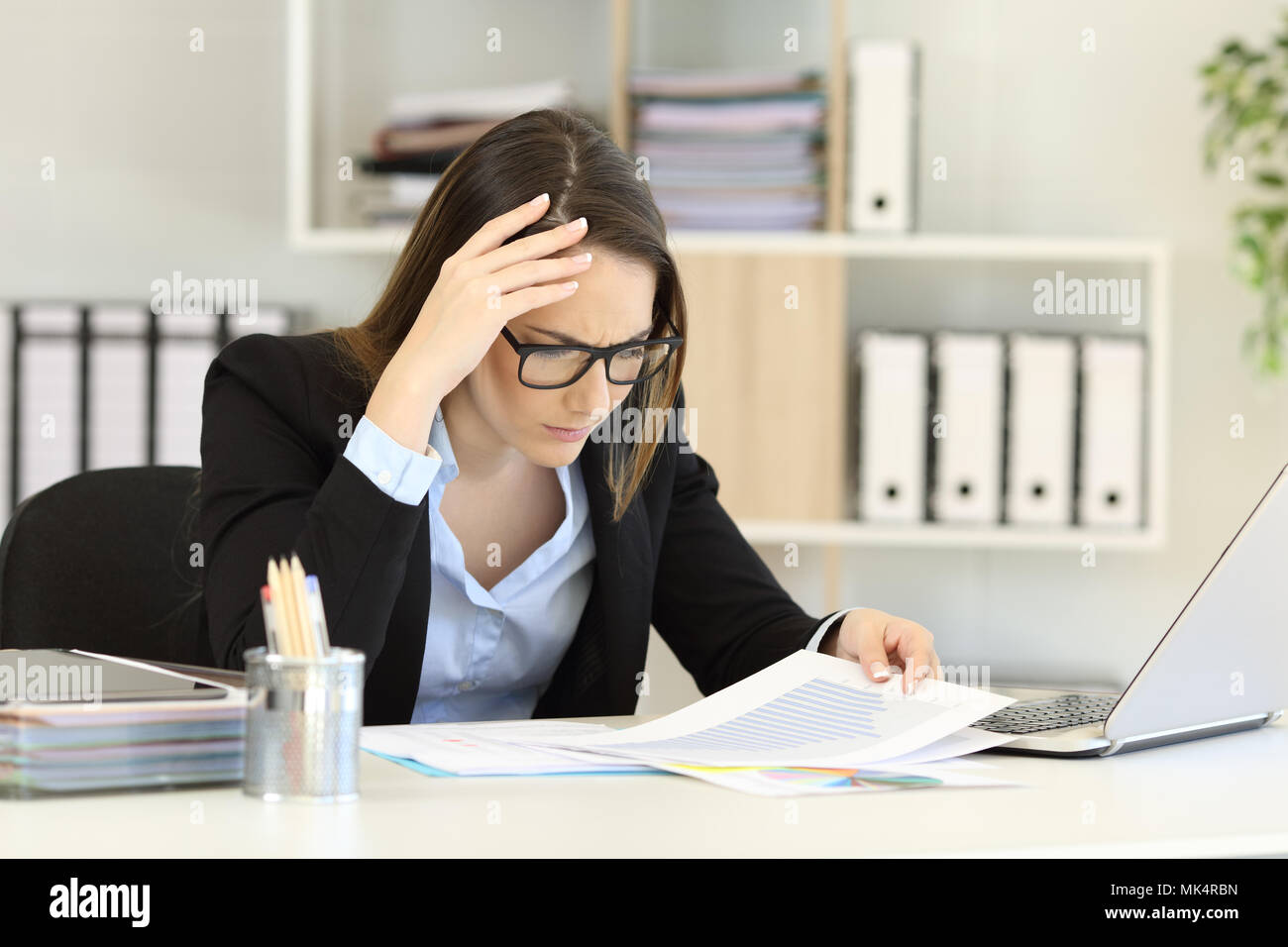 Worried executive checking sales decrease in a negative chart Stock Photo