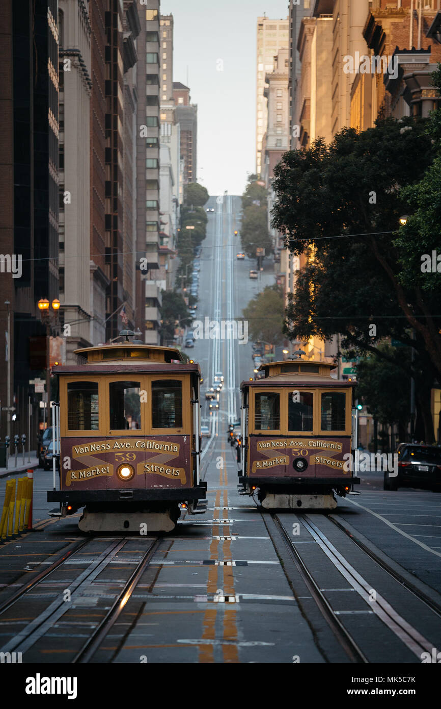 Historic traditional Cable Cars riding on famous California Street in light at sunrise with retro vintage effect, San Francisco, California, USA Stock Photo