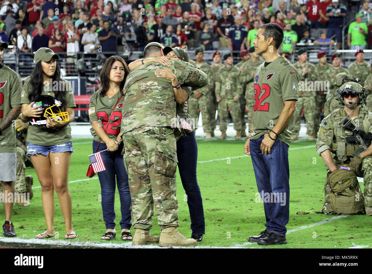 A U.S. Army Ranger hugs Gold Star Family members of a fallen Ranger after  presenting them with a custom U.S. Army Special Operations Command football  helmet at University of Phoenix Stadium. The