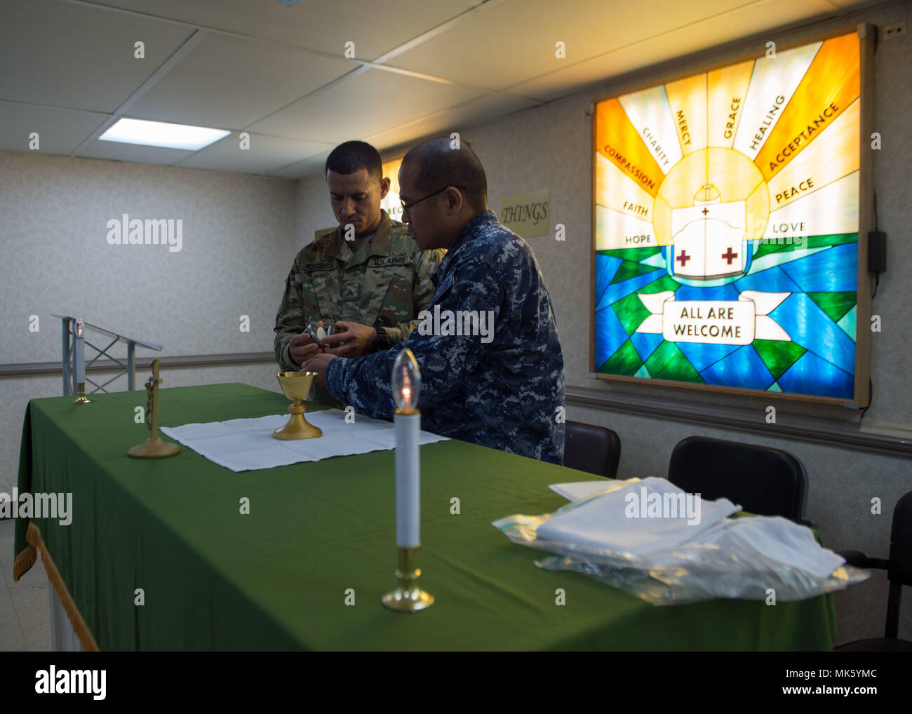 171109-N-MU198-001 SAN JUAN, Puerto Rico (Nov. 9, 2017) Religious Program Specialist 1st Class Adonis Albia (right) and Sgt. Juan Rios prepare the chapel aboard the Military Sealift Command hospital ship USNS Comfort (T-AH 20) for Catholic mass. Comfort is moored pier side in San Juan, Puerto Rico, to provide humanitarian relief. The Department of Defense is supporting the Federal Emergency Management Agency, the lead federal agency, in helping those affected by Hurricane Maria to minimize suffering and is one component of the overall whole-of-government response effort. (U.S. Navy photo by Ma Stock Photo