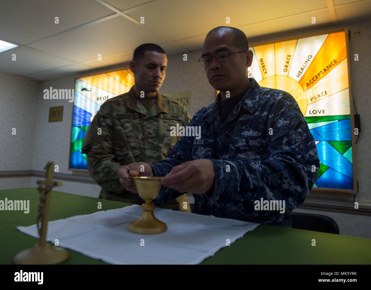 171109-N-MU198-003 SAN JUAN, Puerto Rico (Nov. 9, 2017) Religious Program Specialist 1st Class Adonis Albia (right) and Sgt. Juan Rios prepare the chapel aboard the Military Sealift Command hospital ship USNS Comfort (T-AH 20) for Catholic mass. Comfort is moored pier side in San Juan, Puerto Rico, to provide humanitarian relief. The Department of Defense is supporting the Federal Emergency Management Agency, the lead federal agency, in helping those affected by Hurricane Maria to minimize suffering and is one component of the overall whole-of-government response effort. (U.S. Navy photo by Ma Stock Photo