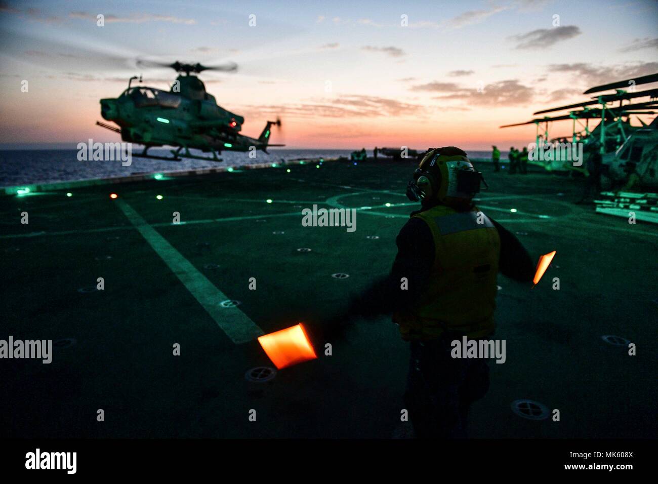 171106-N-BK384-101 MEDITERRANEAN SEA (Nov. 6, 2017) Aviation Boatswain’s Mate (Handling) 3rd Class Esmerelda Hernandez, from Corpus Christi, Texas, and assigned to the air department aboard the San Antonio-class amphibious transport dock ship USS San Diego (LPD 22), directs an AH-1Z Viper, attached to Marine Medium Tiltrotor Squadron (VMM) 161 (reinforced), on the ship’s flight deck Nov. 6, 2017. San Diego is deployed with the America Amphibious Ready Group and the 15th Marine Expeditionary Unit to support maritime security and theater security cooperation in efforts in the U.S. 6th Fleet area Stock Photo