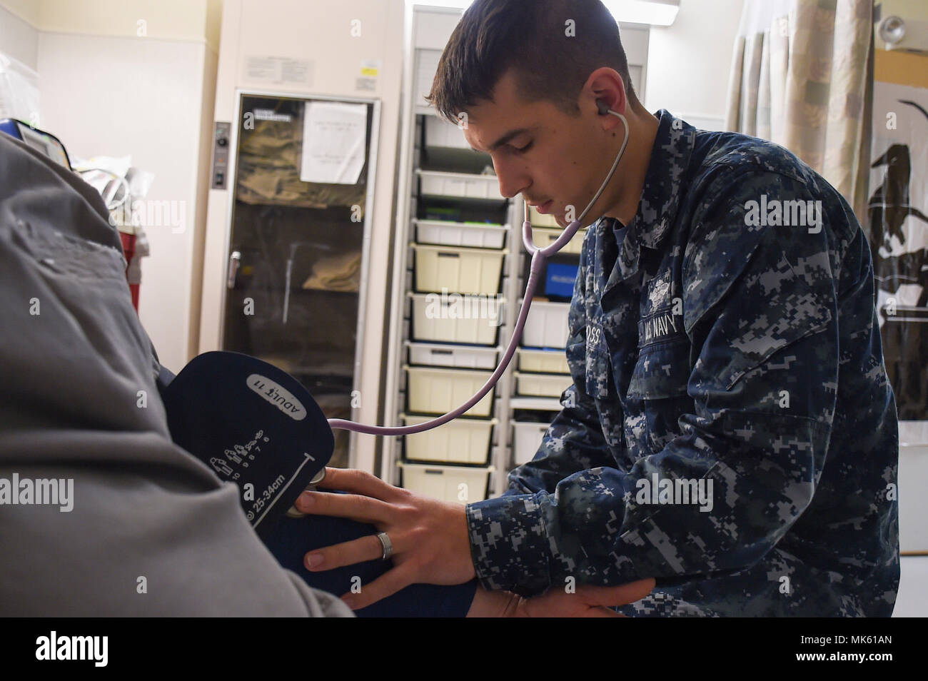171102-N-NR998-012  BREMERTON, Wash.  Hospital Corpsman 3rd Class Aaron Cross from Milwaukie Ore., manually checks a patient's blood pressure at the Urgent Care Center at Naval Hospital Bremerton. (U.S. Navy Photo by Mass Communication 1st Class Gretchen M. Albrecht/ Released) Stock Photo