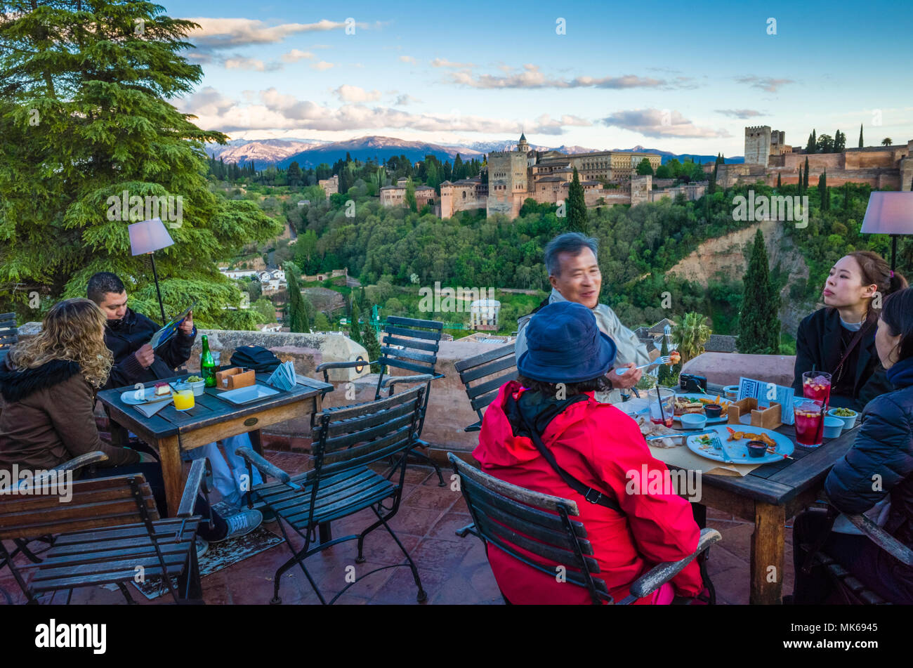 Granada, Andalusia, Spain - April 29th, 2018 : Tourists at Huerto de Juan Ranas cafe and restaurant in the Albaicin district old town, enjoy a panoram Stock Photo