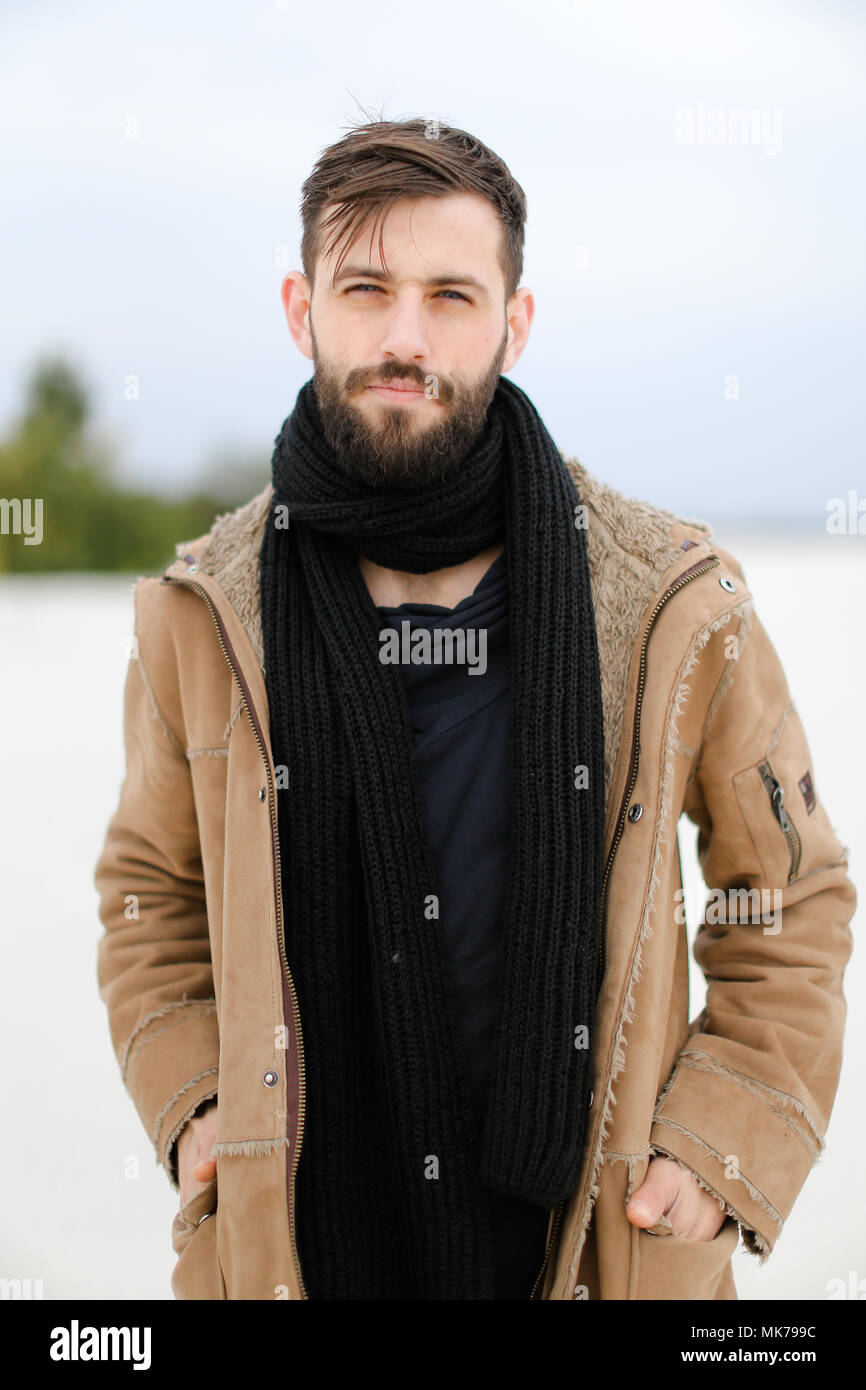 Portrait of young american man with beard wearing coat and black 