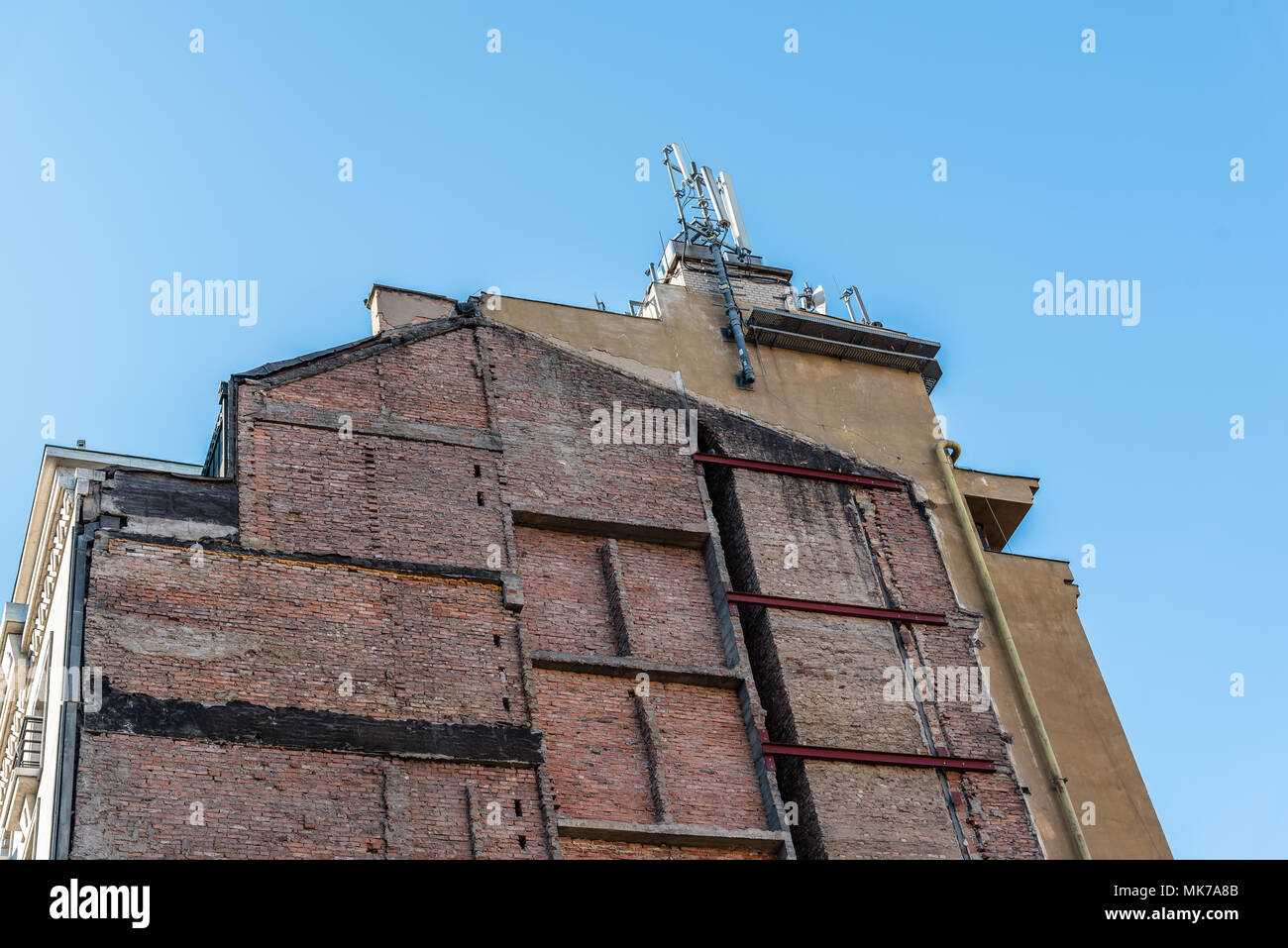 Dividing wall of old residential building against blue sky Stock Photo