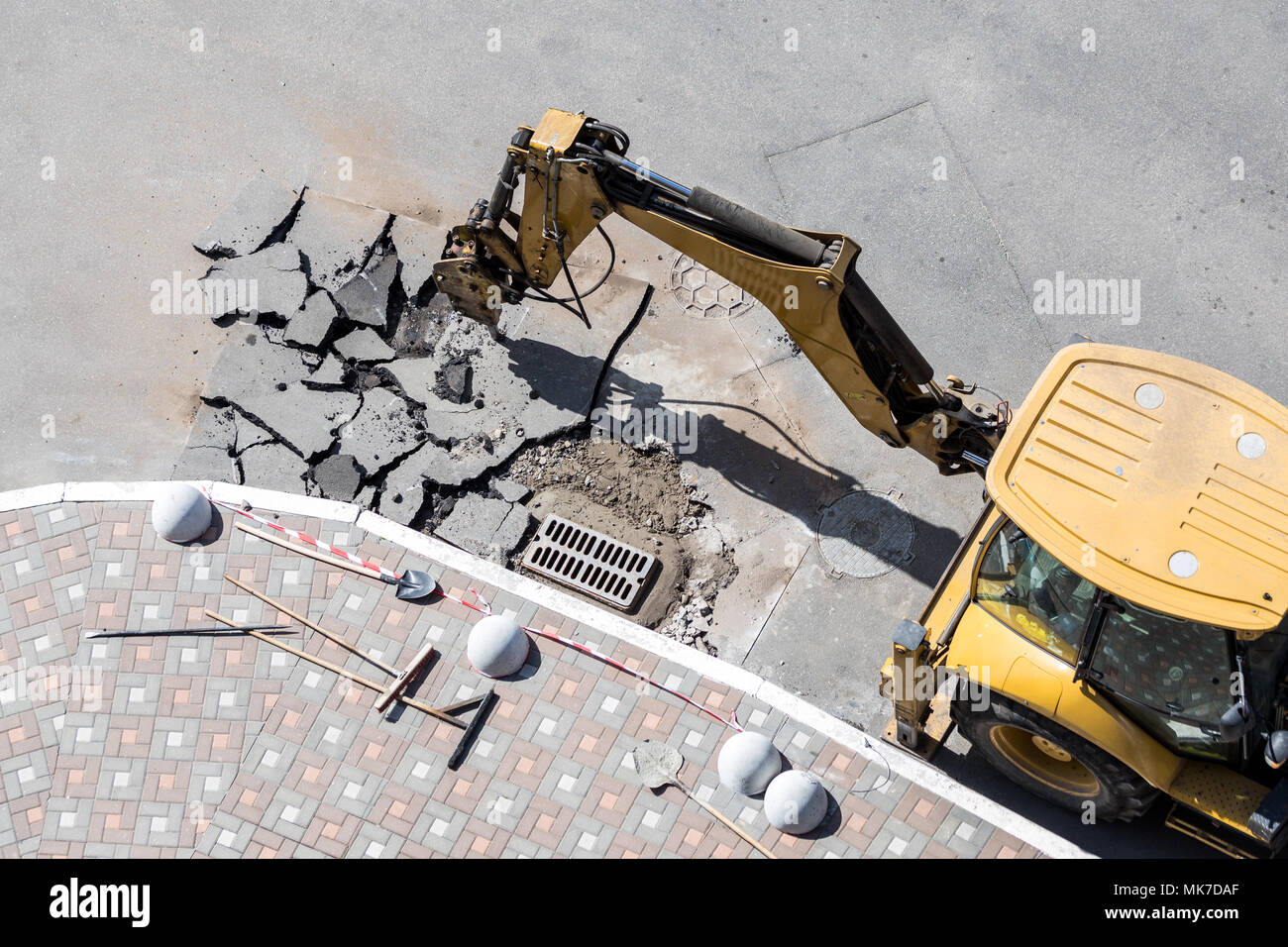 Big jackhammer drill drilling road.Heavy machinery crushing asphalt for