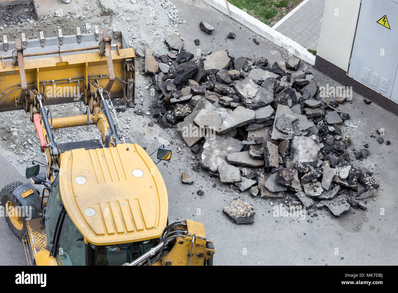 Big jackhammer drill drilling road.Heavy machinery crushing asphalt for