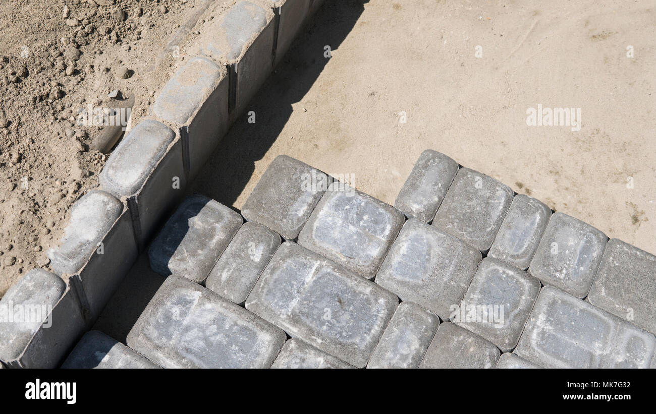 Process of fitting laying new exterior paving stones carefully placing