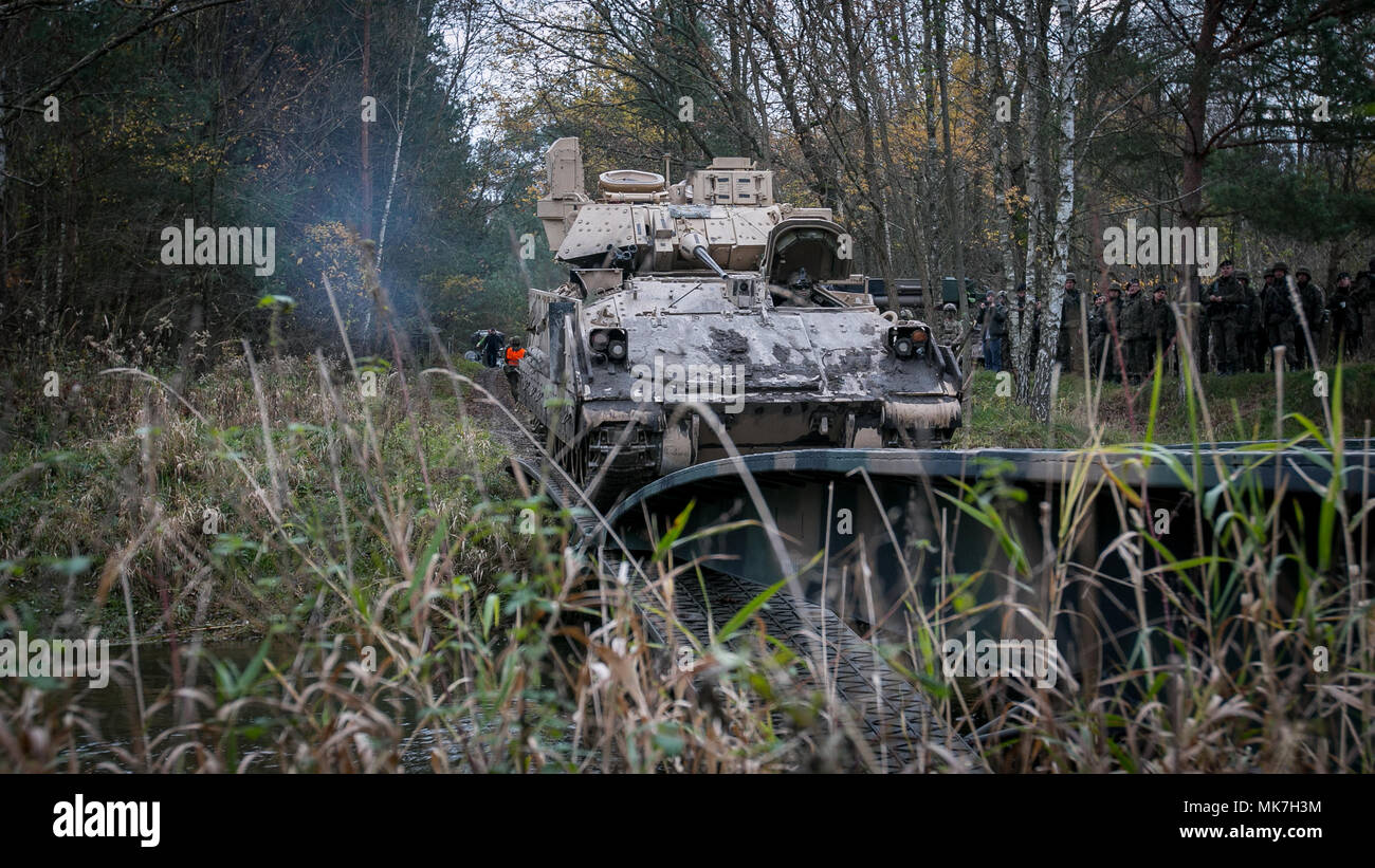 Soldiers from 5th Squadron, 4th Cavalry Regiment, 2nd Armored Brigade Combat Team, 1st Infantry Division from Fort Riley, Kansas, drive a M-113 Armored Personnel Carrier across the Kwisa River in Poland during a multi-national gap crossing exercise on Nov. 16, 2017. The U.S. Army, its allies and partners forge a dynamic presence with a powerful land network that simultaneously deters aggression and assures the security of the region.  (Photo by U.S. Army Spc. Dustin Biven/22nd Mobile Public Affairs Detachment) Stock Photo