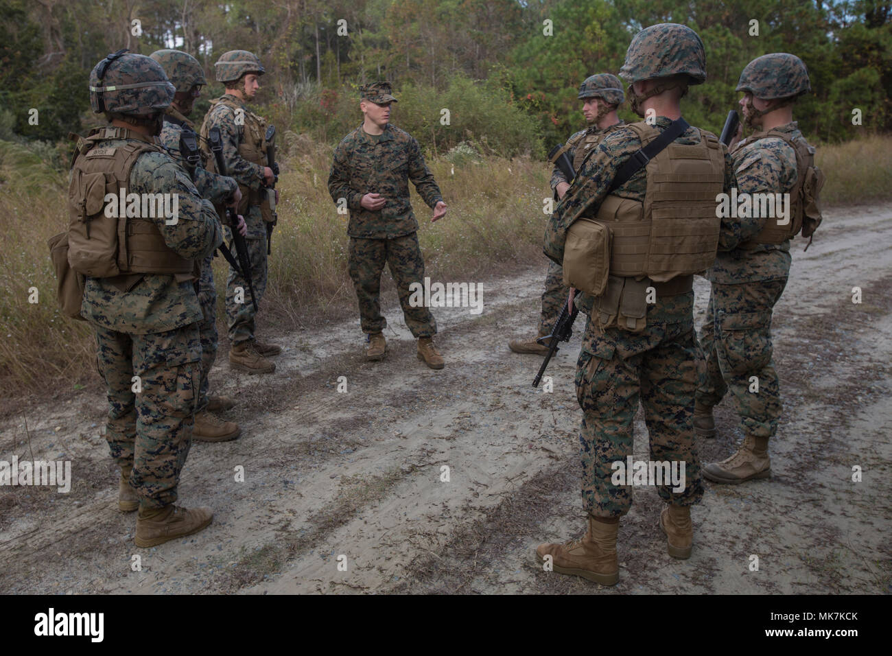 Sgt. Timothy Buntting, an infantry squad leader with 3rd Battalion, 8th Marine Regiment, talks to artillery Marines from 2nd Battalion, 10th Marine Regiment about their performance during a training patrol at Camp Lejeune, N.C., Nov. 14, 2017. The infantry Marines taught the artillerymen advanced patrolling tactics in preparation for their upcoming deployment. (U.S. Marine Corps photo by Lance Cpl. Ashley McLaughlin) Stock Photo