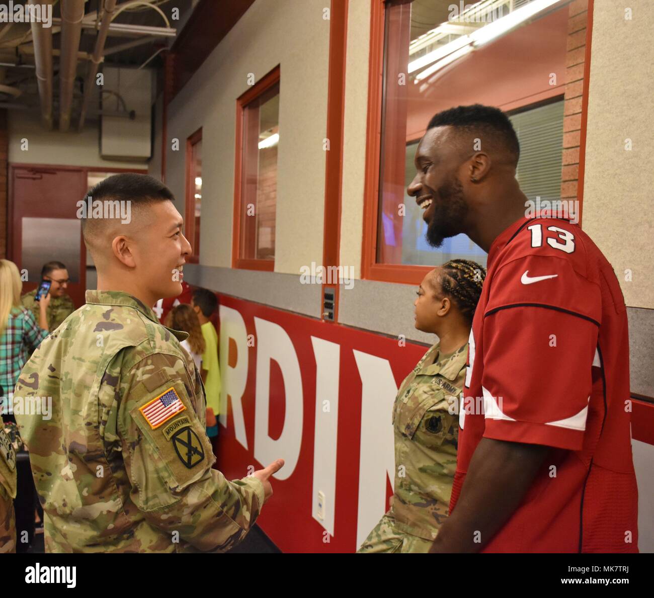 Capt. Eugene Lee, commander, Phoenix West Recruiting Center, enjoys a joke  with Jaron Brown, wide receiver, Arizona Cardinals, during the 8th 'Pro vs  G.I. Joe' video game competition, where recruiters competed against