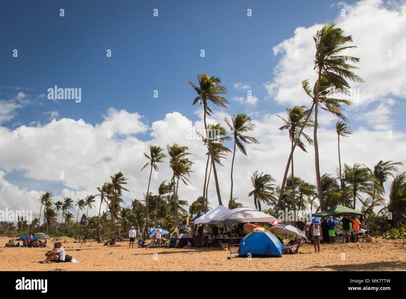 SAN JUAN, Puerto Rico — Families and hosts set up tents during the La Comprita charitable surf competition in Aviones, Puerto Rico, Nov. 11, 2017. The competition is hosted by Agua Salá Ministries, founded by Yossua Lugo over six years ago. Agua Salá is a religious outreach program focusing on helping improve Puerto Rican communities through donations and charitable works. Members of the ministry teach regular surf lessons to children, and host the monthly competition. Proceeds from the competition’s entrance fees and merchandise sales go directly to food and clothing donations. Each month a d Stock Photo