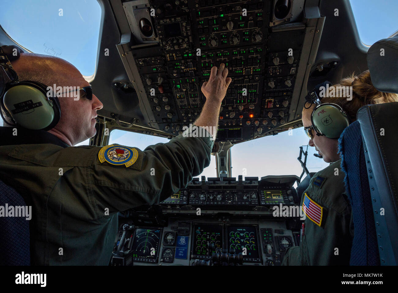 U.S. Air Force Lt. Col. Samuel F. Irvin, left, Commander, 732nd Airlift Squadron, and Capt. Maggie R. Linn, both C-17 Globemaster III Pilots with the 732nd Airlift Squadron, 514th Air Mobility Wing, prepare to land at Joint Base Charleston, S.C., Nov. 17, 2017. The 514th‘s 732nd Airlift Squadron C-17 crew are combining training and a real world Denton Program humanitarian mission bringing 76,410 pounds of food to the Republic of Haiti. The 514th is located at Joint Base McGuire-Dix-Lakehurst, N.J. (U.S. Air Force photo by Master Sgt. Mark C. Olsen) Stock Photo