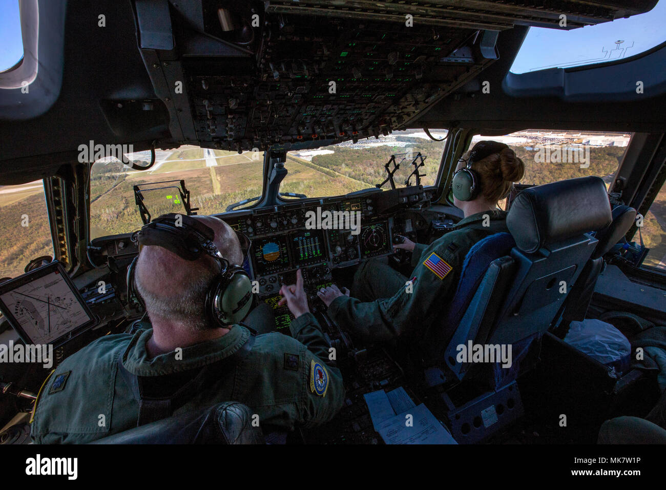 U.S. Air Force Lt. Col. Samuel F. Irvin, left, Commander, 732nd Airlift Squadron, and Capt. Maggie R. Linn, both C-17 Globemaster III Pilots with the 732nd Airlift Squadron, 514th Air Mobility Wing, make their final approach at Charleston Air Force Base, S.C., Nov. 17, 2017. The 514th‘s 732nd Airlift Squadron C-17 crew are combining training and a real world Denton Program humanitarian mission bringing 76,410 pounds of food to the Republic of Haiti. The 514th is located at Joint Base McGuire-Dix-Lakehurst, N.J. (U.S. Air Force photo by Master Sgt. Mark C. Olsen) Stock Photo