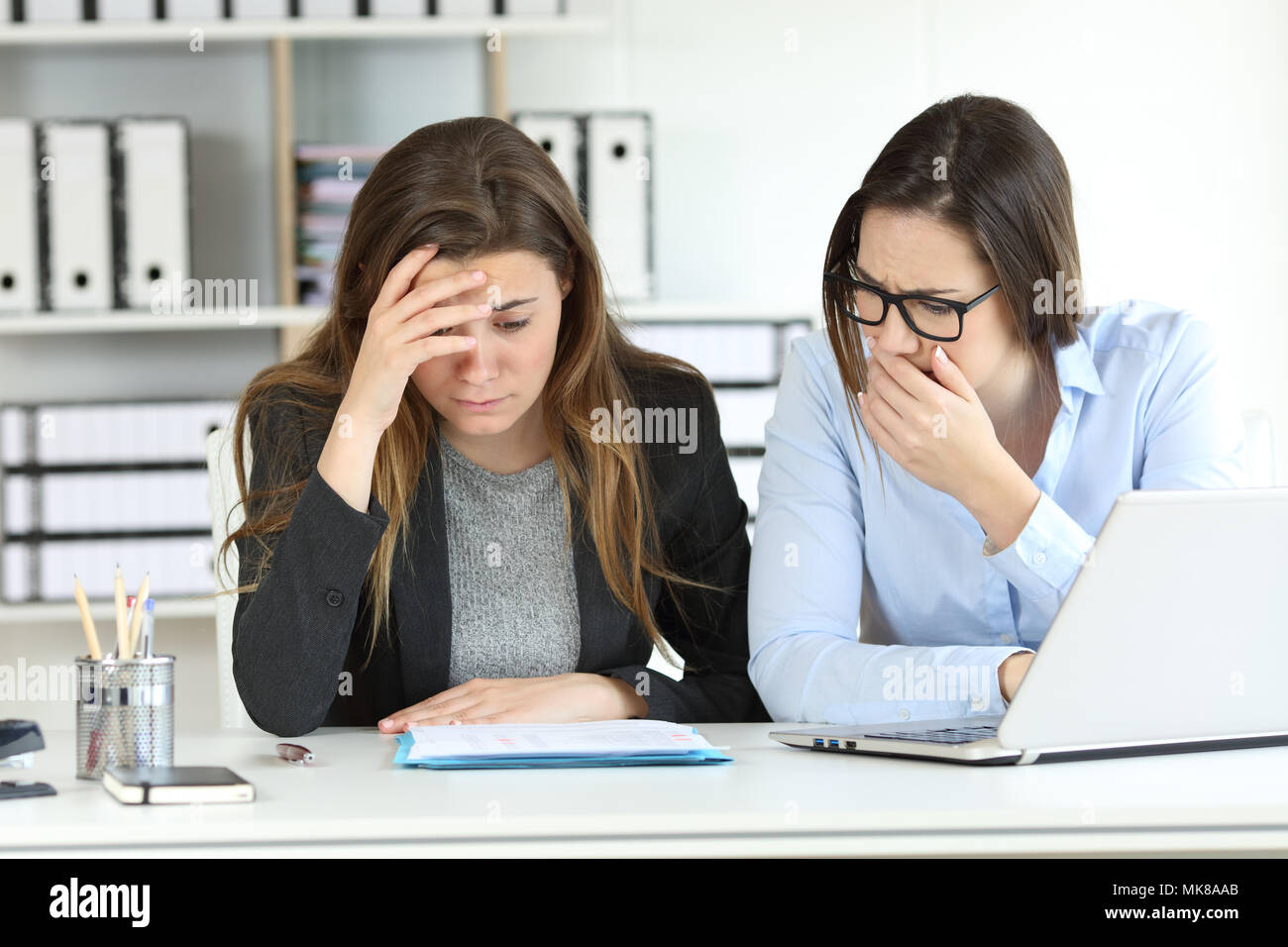 Worried office workers discovering a mistake in a document Stock Photo