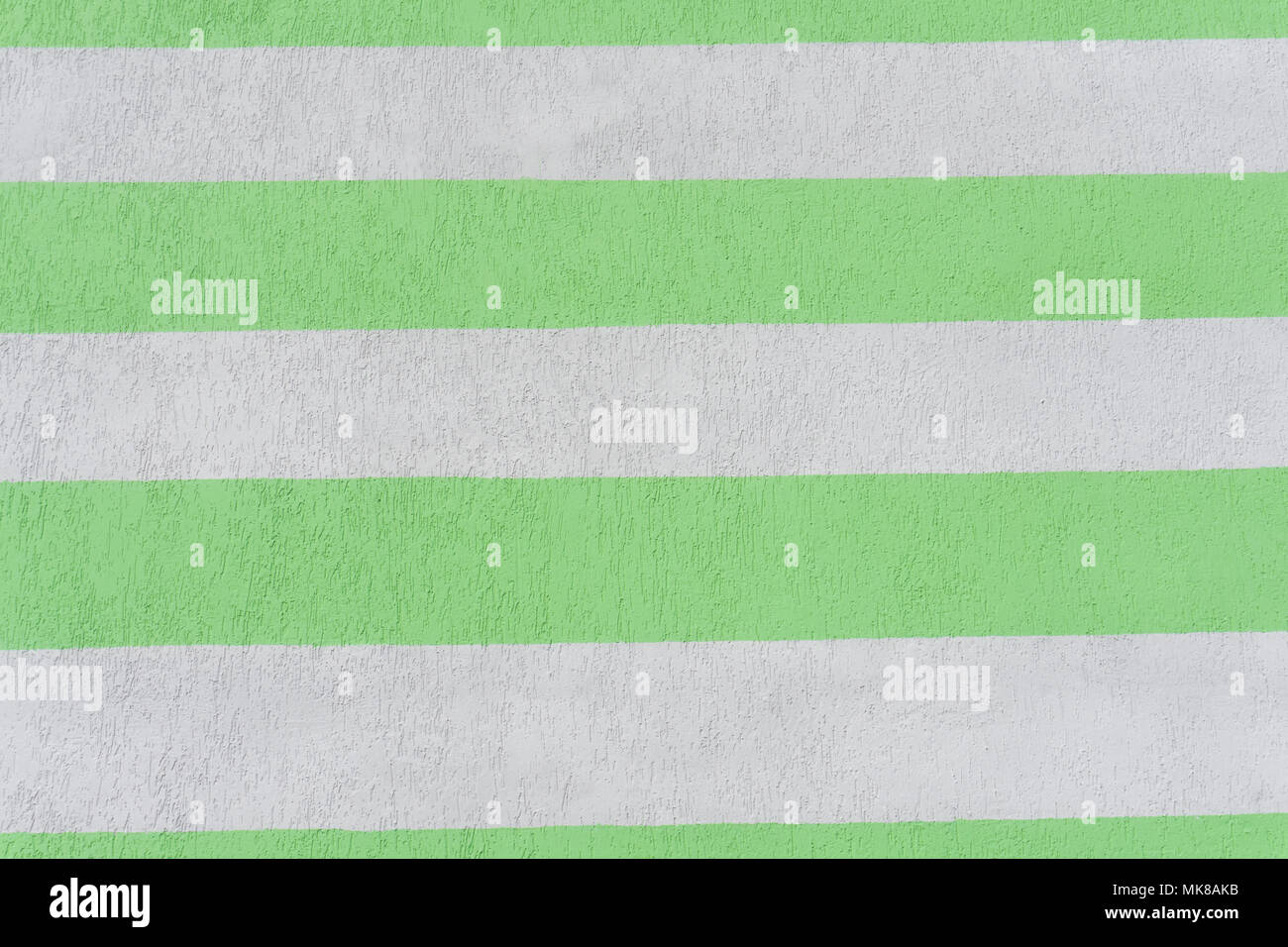 parallel strips of beige and green color on the plastered wall. Background Stock Photo