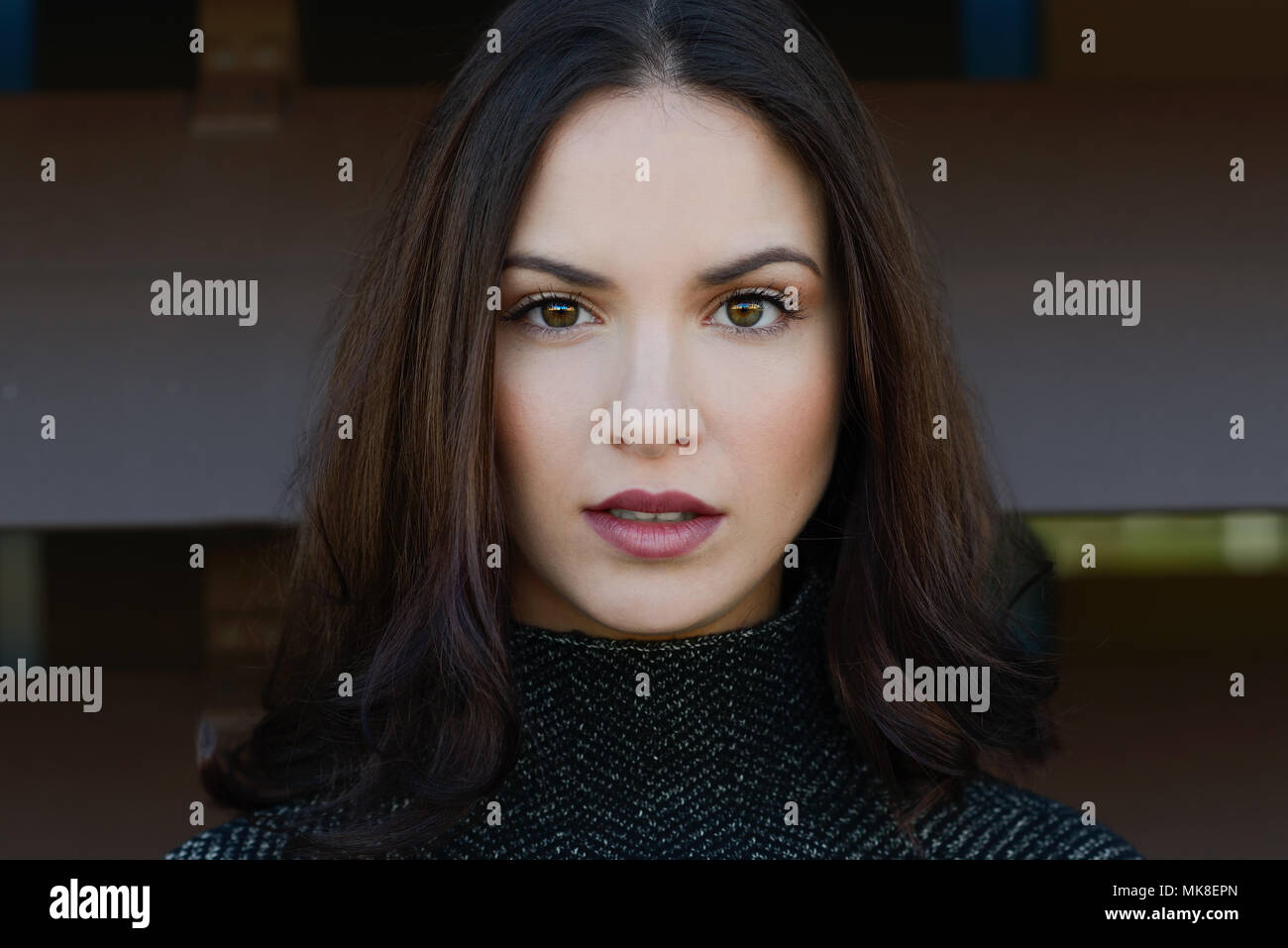 Close-up portrait of beautiful young woman looking at camera with ...