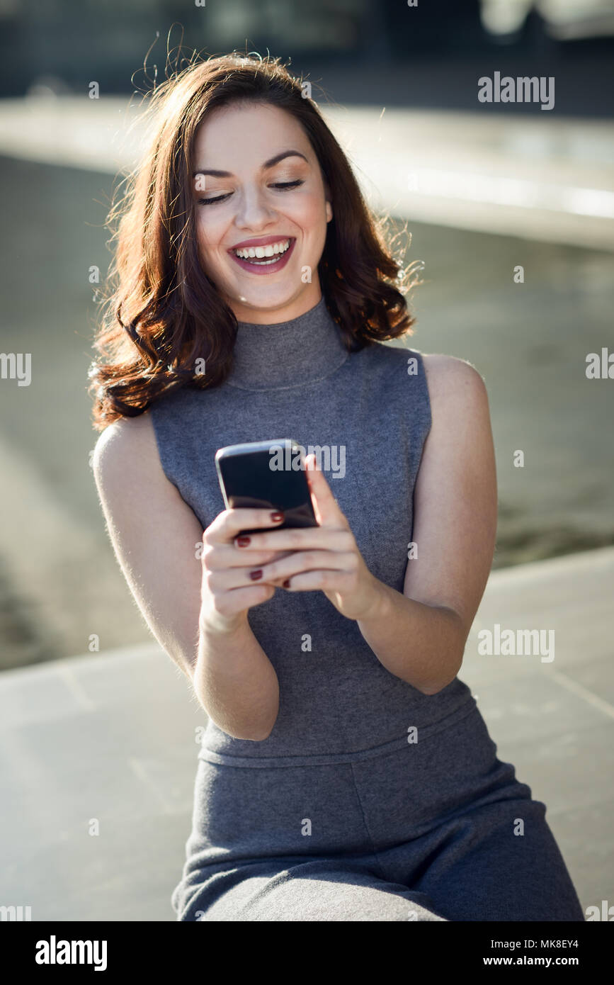 Beautiful young woman with a smartphone in an office building Stock Photo