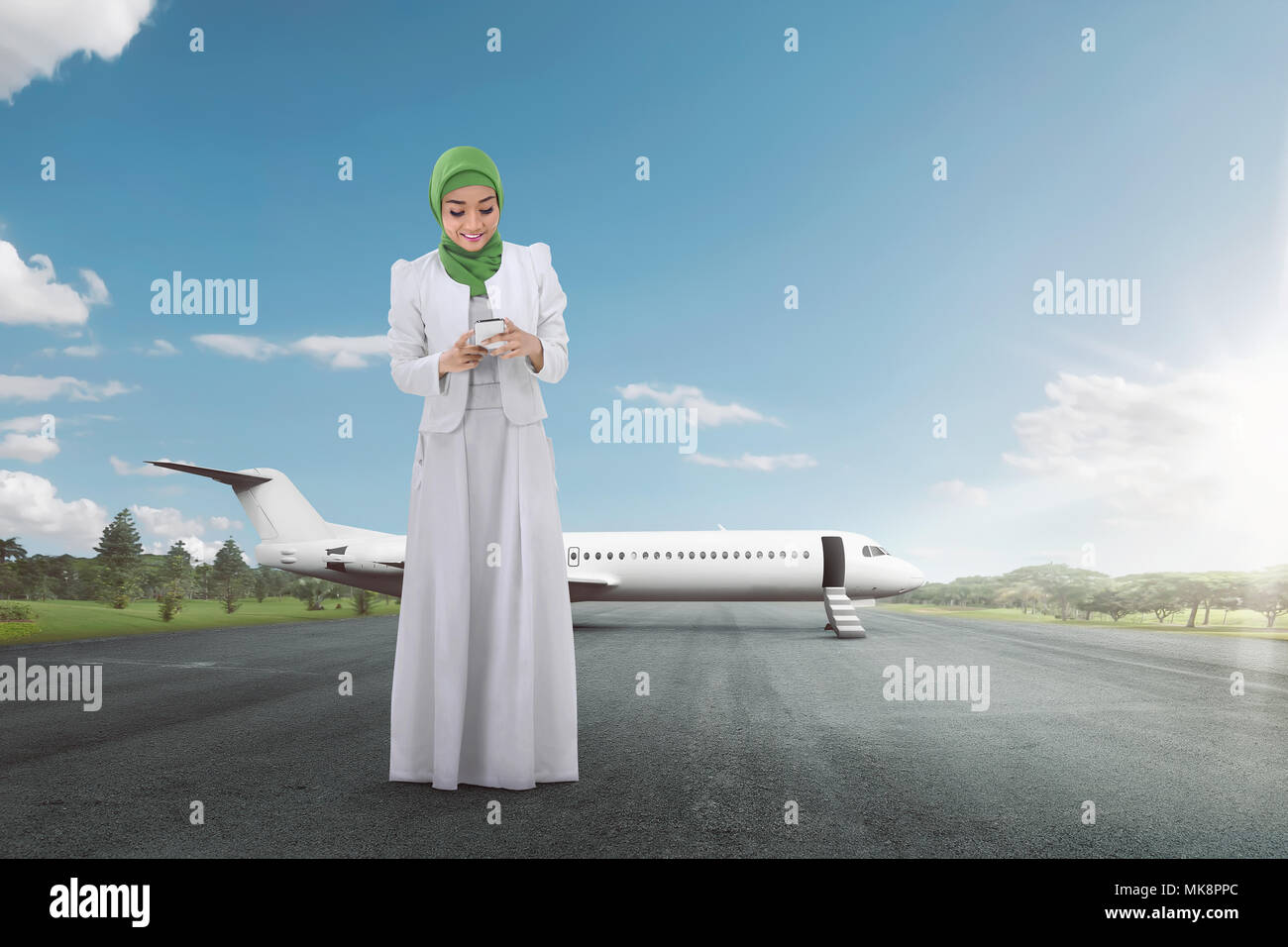 Pretty asian muslim woman using mobile phone on the airport Stock Photo ...