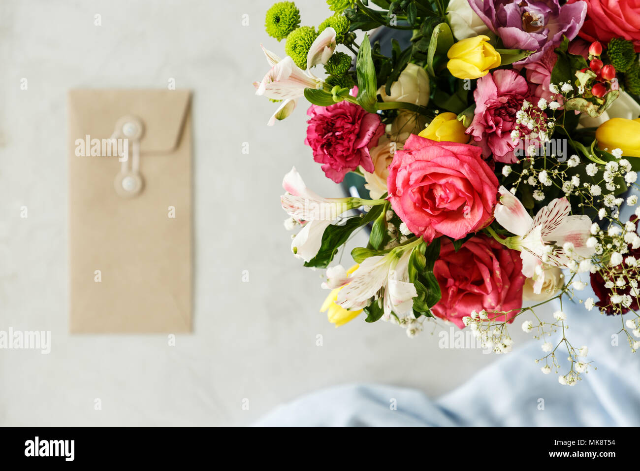 Close-up of bouquet of red roses, yellow tulips and white flowers on blurred background with copy space. Valentine's day concept Stock Photo