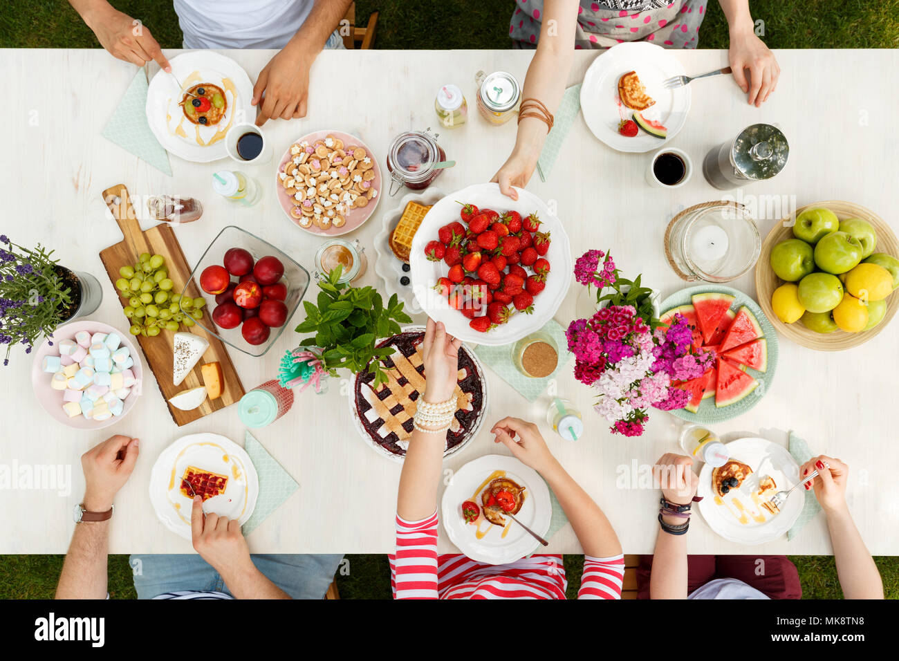 Multicultural group having a meal, sharing food in the garden outside