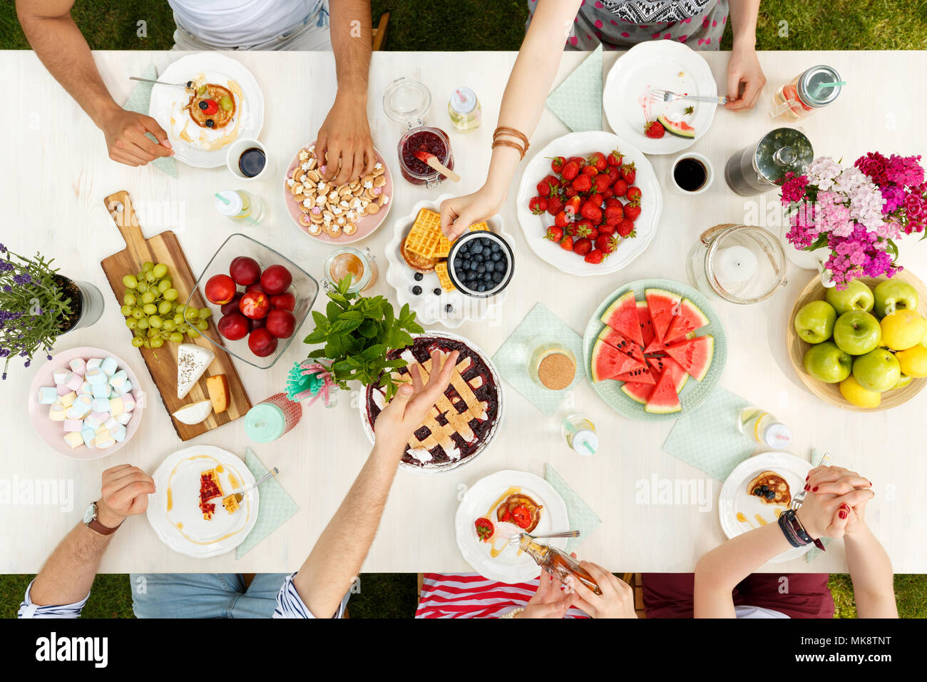 Mixed-race group of students sitting outside and sharing a meal of ...