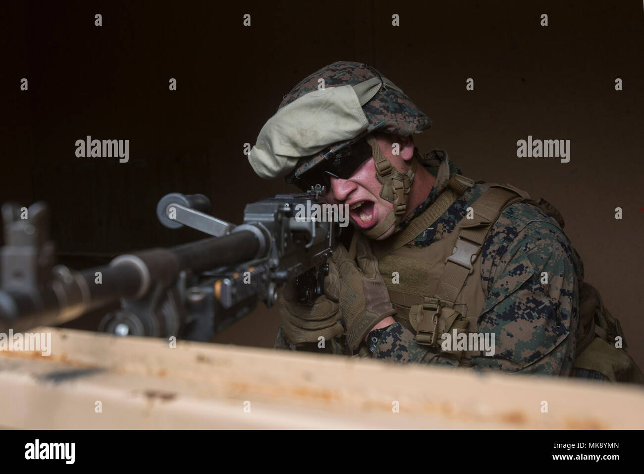 A Marine with 1st Battalion, 2nd Marine Regiment yells to simulate firing a M240 machine gun during a military operations on urbanized terrain exercise at Marine Corps Base Camp Lejeune, N.C., Nov. 21, 2017. The Marines conducted MOUT training to maintain combat readiness. (U.S. Marine Corps photo by Lance Cpl. Ashley McLaughlin) Stock Photo