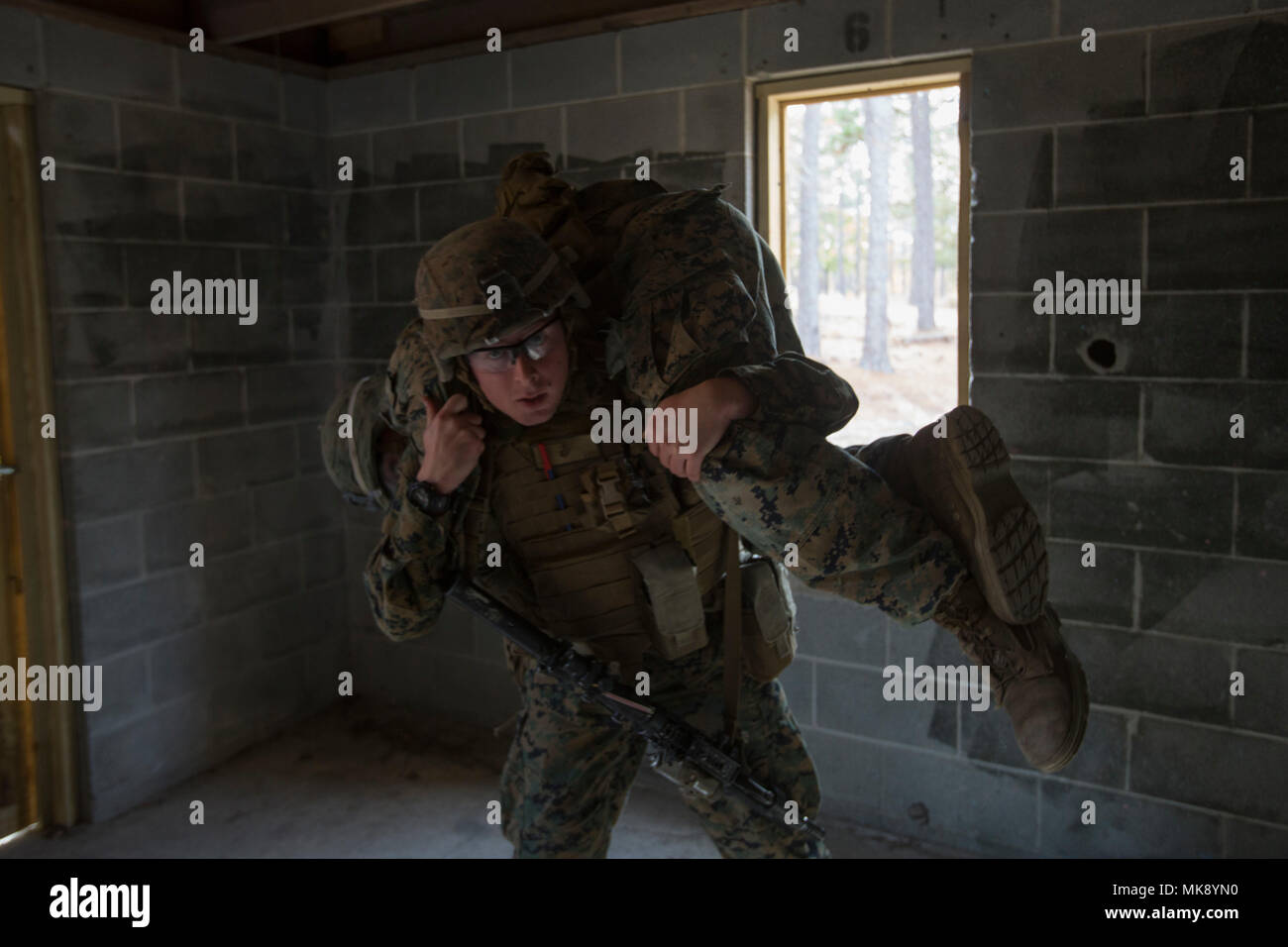 A Marine with 1st Battalion, 2nd Marine Regiment fireman carries a casualty to a safe zone during a military operations on urbanized terrain exercise at Marine Corps Base Camp Lejeune, N.C., Nov. 21, 2017. The Marines conducted MOUT training to maintain combat readiness. (U.S. Marine Corps photo by Lance Cpl. Ashley McLaughlin) Stock Photo