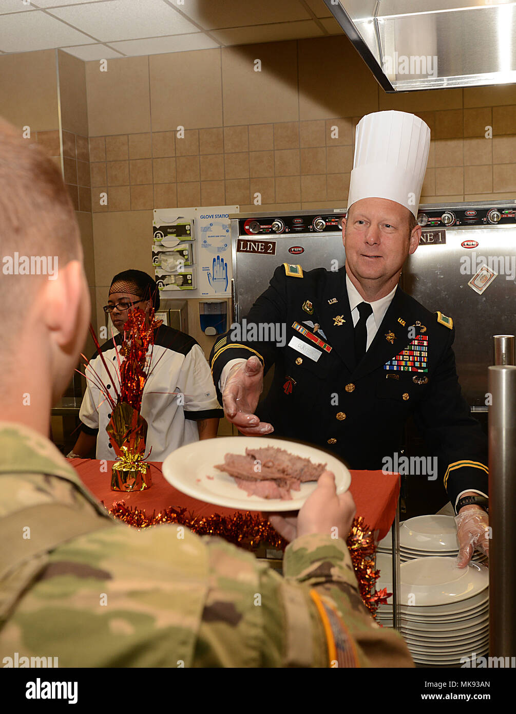 U.S. Army Col. Ralph Clayton III, 733rd Mission Support Group commander, serves Thanksgiving lunch at the Warrior Cafe on Joint Base Langley-Eustis, Va., Nov. 23, 2017. The Thanksgiving meal included traditional dishes such as turkey, ham, potatoes and an array of desserts, provided by the dining facilities. (U.S. Air Force photo by Staff Sgt. Teresa J. Cleveland) Stock Photo