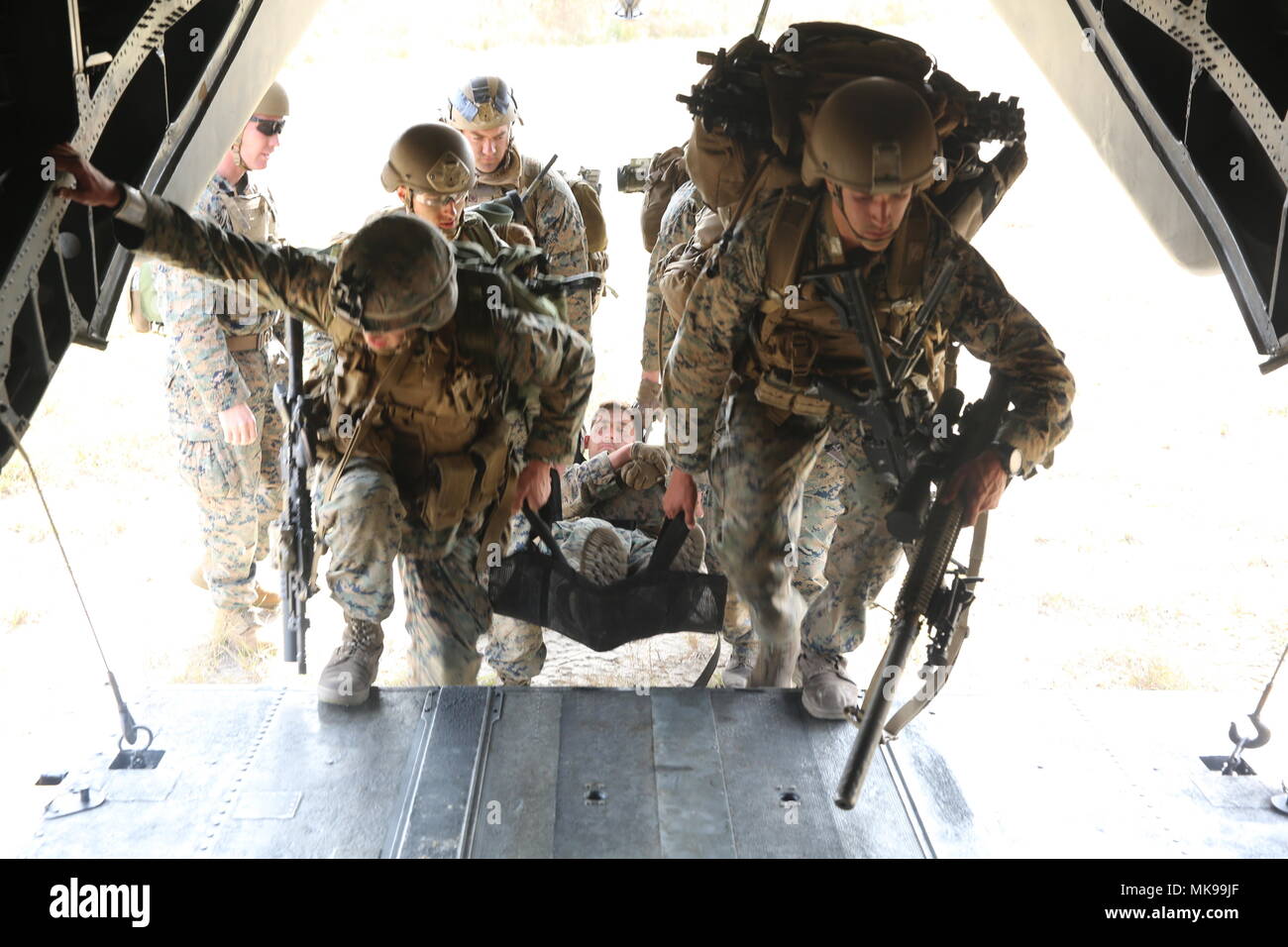 Marines assigned to Scout Sniper School load a simulated casualty into