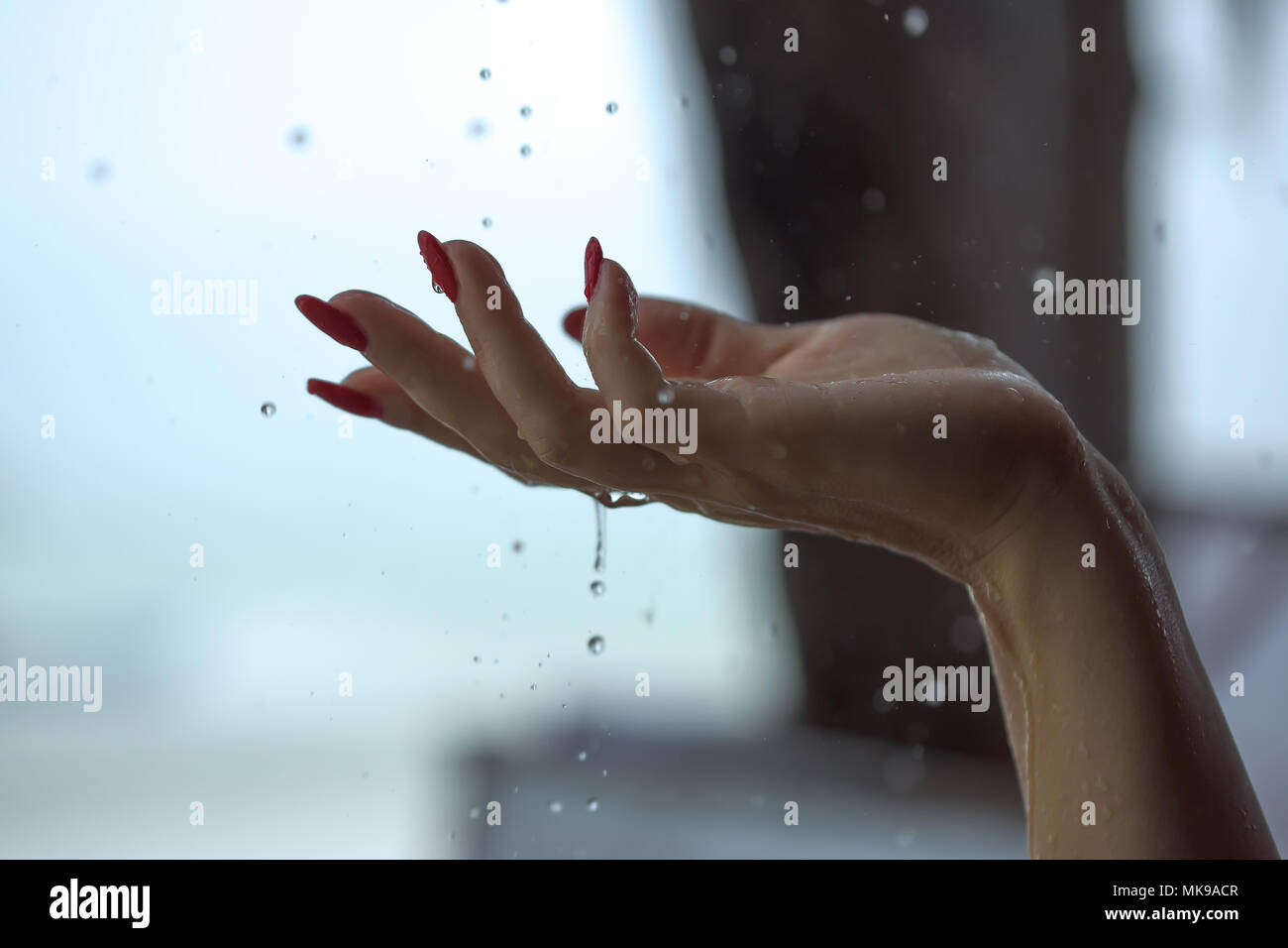 Rain drops falling on woman's hand Stock Photo - Alamy