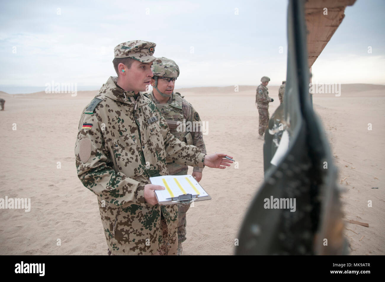 U.S. service members hold themselves above the bar during the flexed