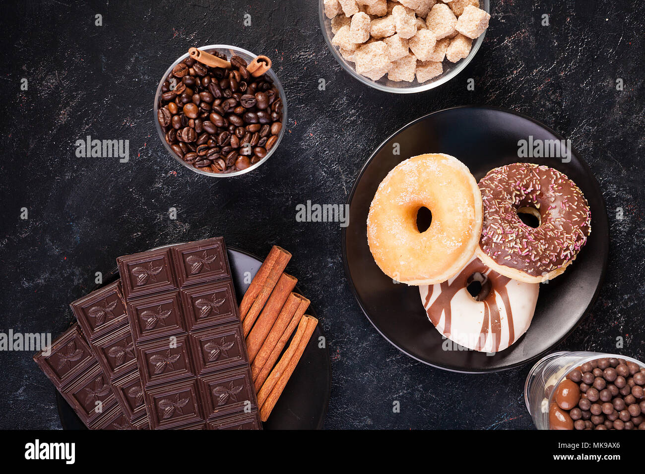 Top view of chocolate tablets, donuts, brown sugar with peanuts in