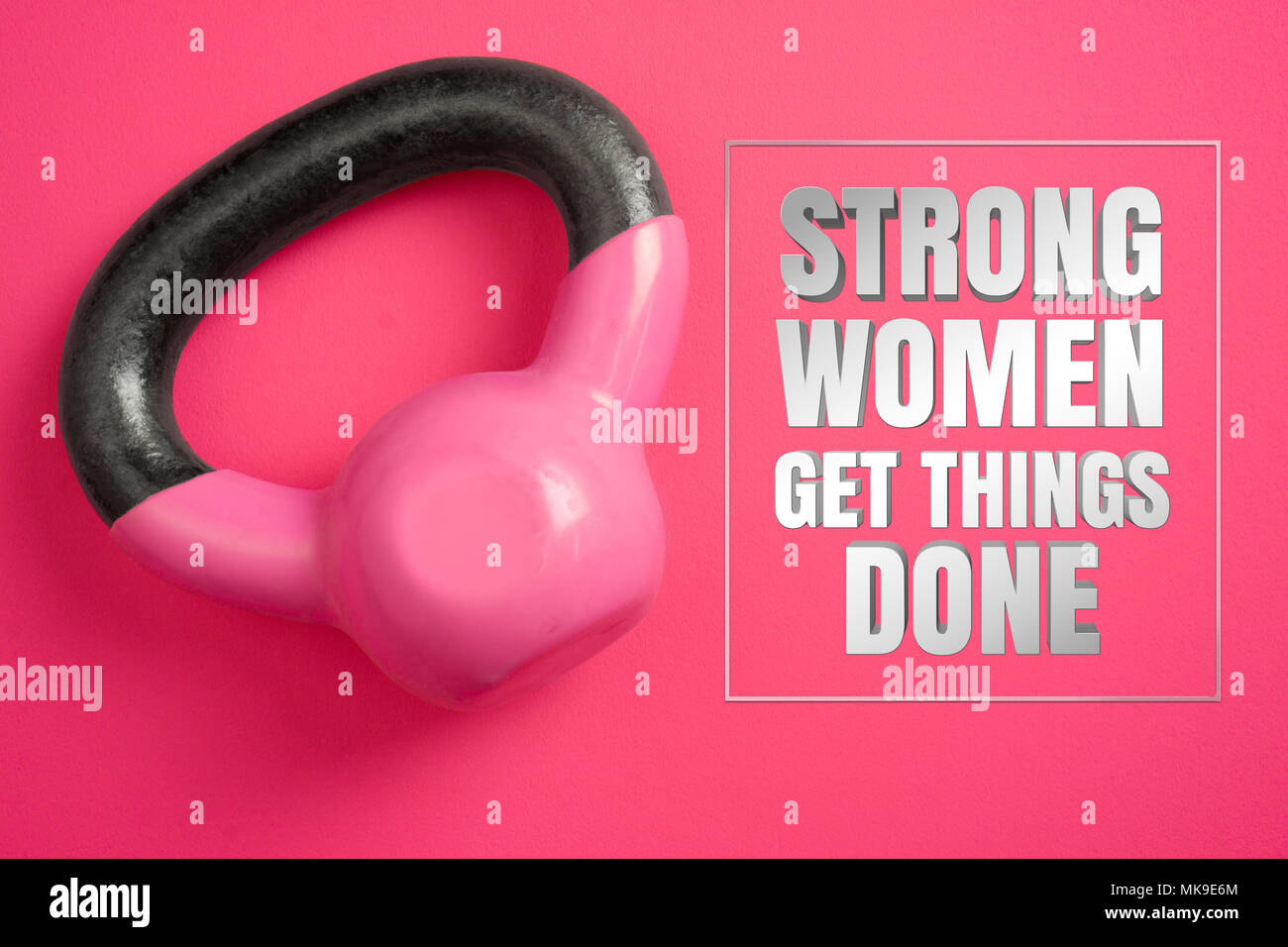 Strong women get things done. Inspirational quote with women's kettle weights on pink background. Stock Photo