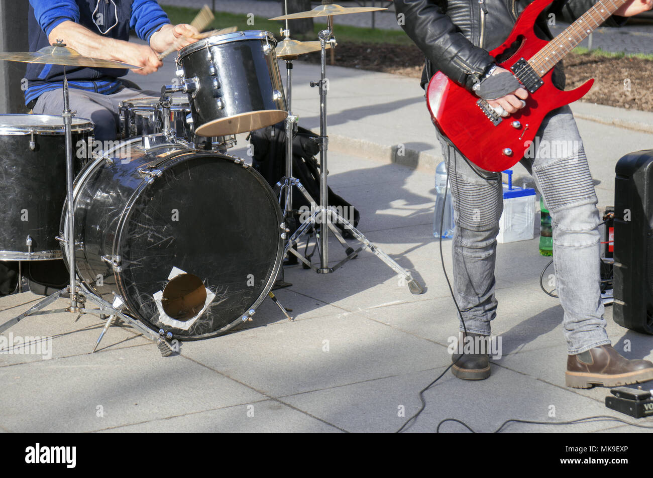 Street musicians playing on guitar and drums. Unrecognizable persons. Stock Photo