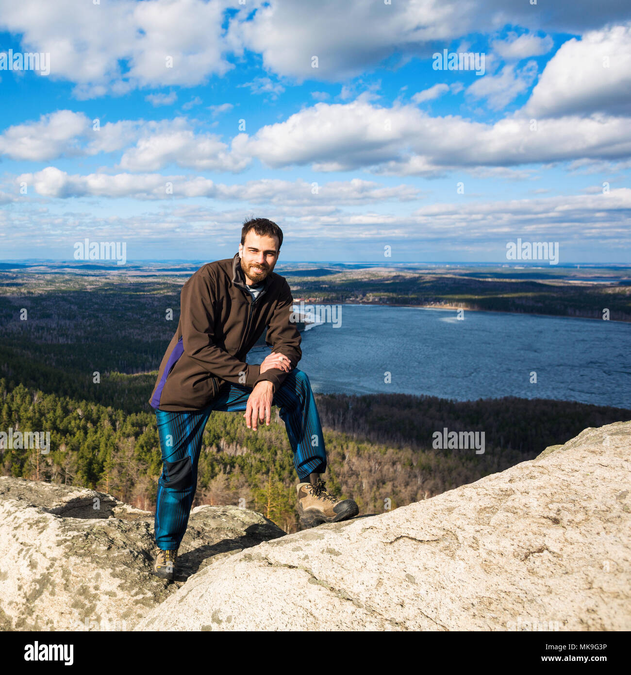 Young man standing on the top of the rock. Stock Photo