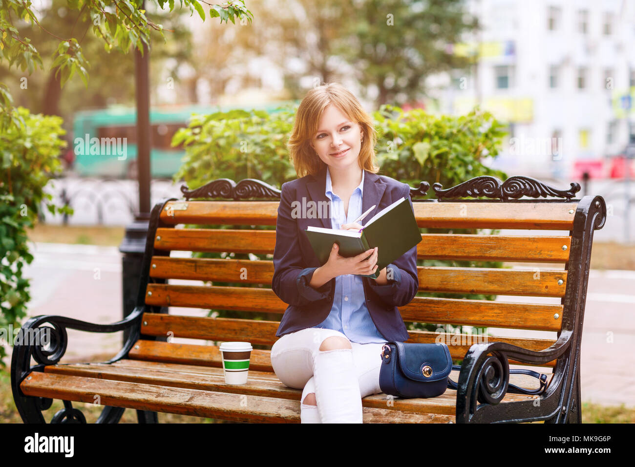Young woman studying and writing in a park. Stock Photo