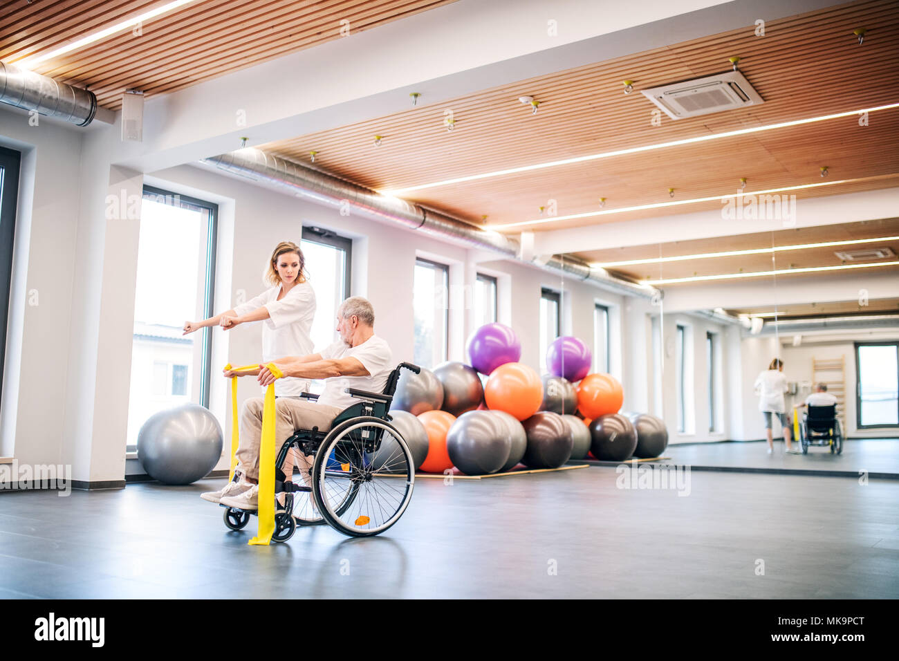 Young woman physiotherapist working with a senior man in wheelchair Stock Photo Alamy